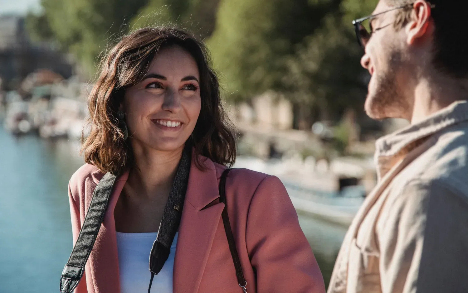 Couple souriant au bord de l'eau, sur les quais à Paris